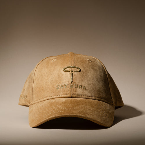ZAY AURA DUNE sand-colored baseball cap with a suede-textured finish, gold embroidered logo and curved brim, shown from the front.