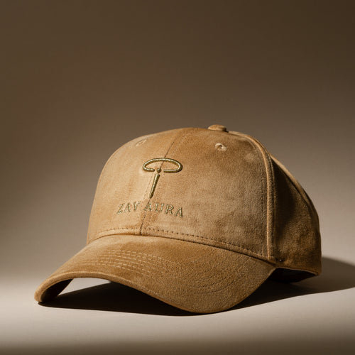 ZAY AURA DUNE sand-colored baseball cap shown at a three-quarter angle, with suede texture, gold embroidered logo and curved brim.